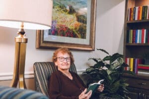 Resident reading a book in the library at Charter Senior Living of Cookeville